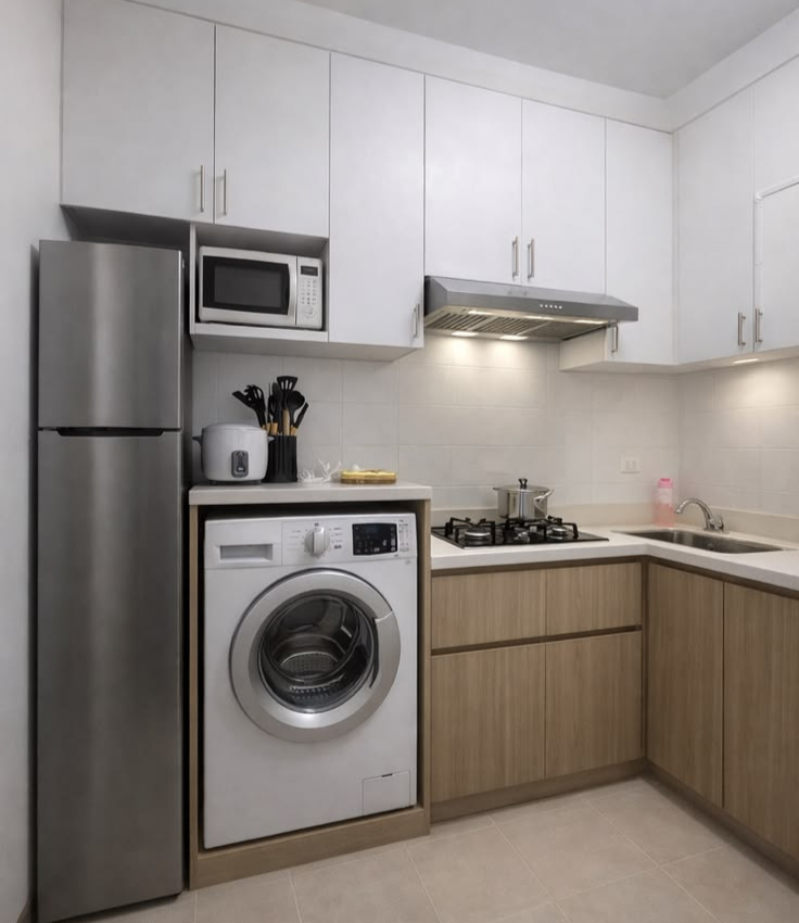 Compact modern modular kitchen featuring white upper cabinets, wood-grain base cabinets, an integrated under-counter washing machine, a built-in microwave niche, and a stainless steel refrigerator.