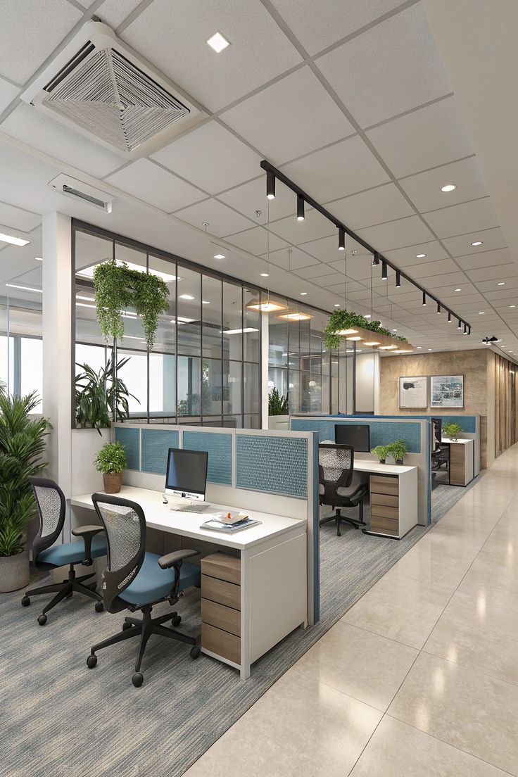 Modern corporate office interior in Hyderabad featuring blue acoustic workstation partitions, ergonomic mesh chairs, track lighting, and glass dividers with hanging indoor plants.