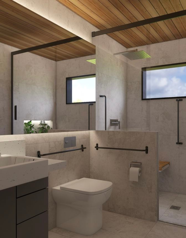 Modern accessible bathroom featuring matte grey anti-skid tiles, a wood-slatted ceiling, matte black grab bars near the toilet and shower, a fold-down shower seat, and a curbless glass shower partition.