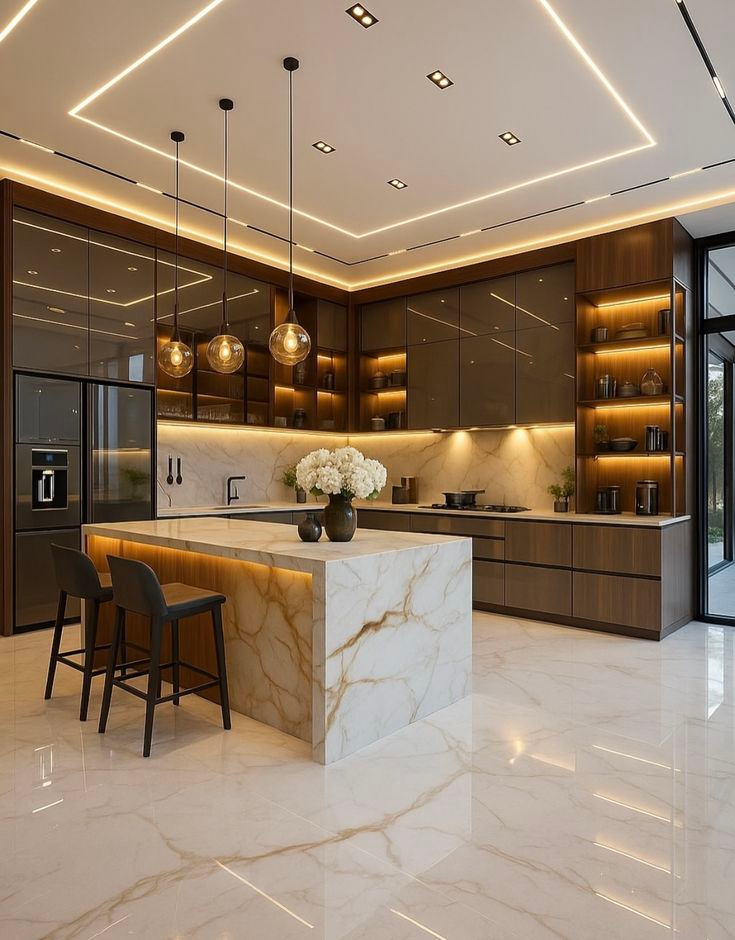 Ultra-luxury L-shaped modular kitchen featuring a dramatic marble waterfall island, dark glossy base cabinets, illuminated tinted glass upper cabinets, and open display shelving under a modern false ceiling.
