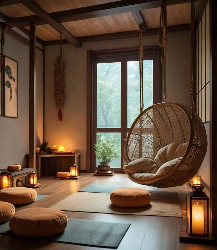 Zen meditation room interior featuring a hanging wicker swing chair, wooden flooring, floor cushions on yoga mats, warm floor lanterns, and a large window with nature views.