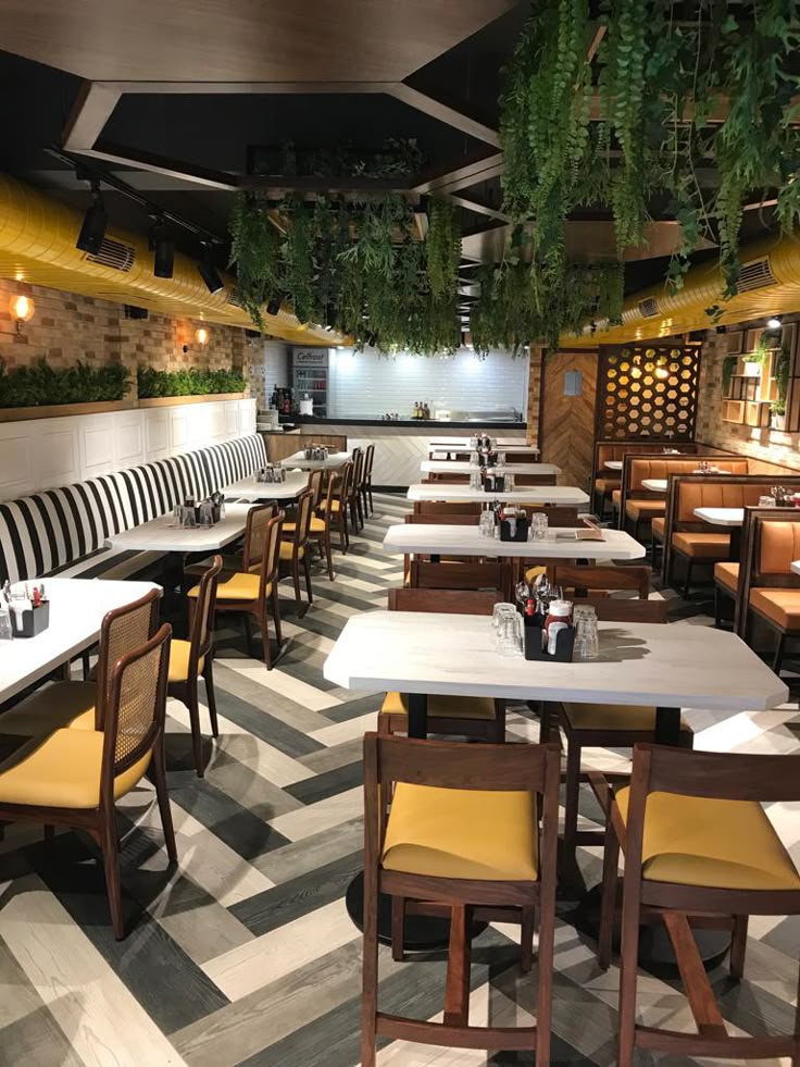 Houseway professional restaurant interior design and commercial fit-out services in Hyderabad, featuring biophilic hanging greenery, custom booths, and herringbone flooring.