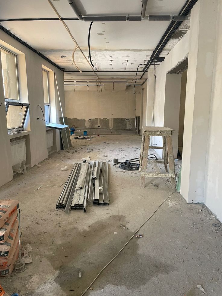 Houseway commercial interior fit-out and office construction site services in Hyderabad, featuring a raw commercial shell during early remodeling with metal framing channels, raw concrete floors, and ceiling wiring.