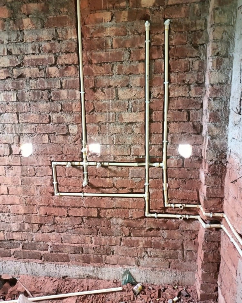 Houseway bathroom plumbing installation and sanitary design services in Hyderabad, featuring a multi-panel visual guide of a professional plumber installing a sink trap, exposed PVC water supply pipe networks, drainage schematics, finished bathroom interiors, and rough-in wall plumbing.
